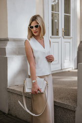 a lady in a white vest and a beige skirt